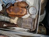 une valise remplie d'objets anciens posée sur une table