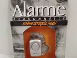 image d'un dispositif d'alarme dans un boîtier posé sur une surface blanche