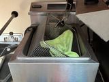 une photo d'une cuisine avec une friteuse et d'autres objets posés sur le plan de travail