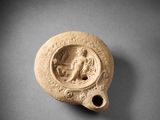 un petit vase en argile sur lequel est représentée une femme