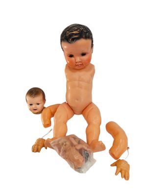 a baby doll sitting on top of a plastic bag