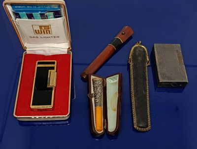 un briquet, un étui à briquet et un briquet posé sur une table bleue