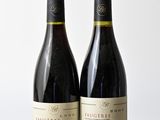 deux bouteilles de vin posées sur une table en bois