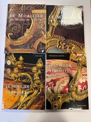 deux livres posés sur une table, à côté d'une chaise dorée et d'une horloge