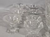 a lot of glass dishes and cups on the table