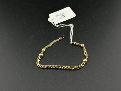 un bracelet en chaîne d'or auquel est attachée une plaque