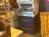 shelves of bread and pastries in a bakery with a cash register