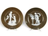 deux assiettes marron et blanches sur lesquelles figure l'image d'un homme et d'une femme