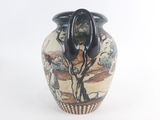 a vase that has a black handle on top of it