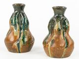 deux vases posés côte à côte sur une surface blanche