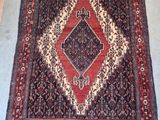 un tapis oriental à motifs de losanges posé sur un sol gris