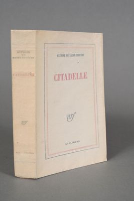 an old book sitting on top of a table on a gray surface