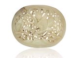 une plaque ovale en jade blanc sculpté, représentant des fleurs et des feuilles sur fond blanc