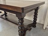 a wooden table with a glass top sitting on the floor