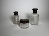trois bocaux en verre avec leurs couvercles, posés sur une surface blanche
