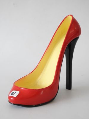 red and yellow high heel shoe with a white tag on the heel