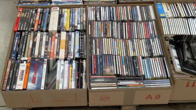 a lot of dvds in a box on the floor