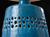 a blue lamp that has holes in the middle of it