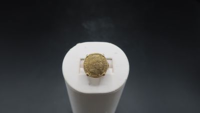 an image of a gold ring sitting on top of a white object