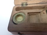 a small wooden box with a small metal object inside of it