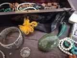 a wooden box filled with assorted jewelry on a table