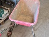 a wheelbarrow with a pink handle in a garage