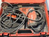 une boîte à outils rouge contenant une perceuse et d'autres outils