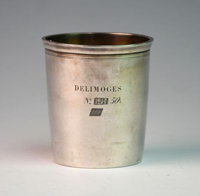 an old silver cup sitting on top of a white table