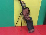 a bag of golf clubs on a tripod next to a yellow and green wall
