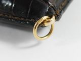an image of a close up of a black purse with a gold ring