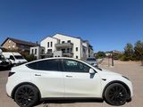 a white tesla suv parked in a parking lot next to a building