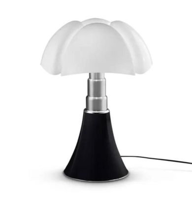 la lampe repose sur un socle noir et est dotée d'un abat-jour blanc