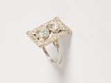 a close up of a diamond ring on a white surface