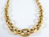 a close up of a gold chain necklace on a white surface