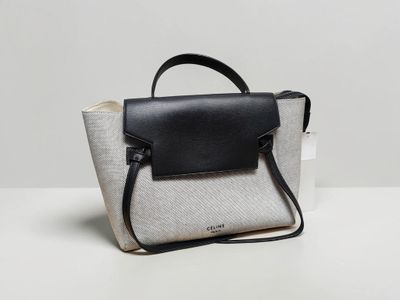 a white and black purse sitting on top of a white table