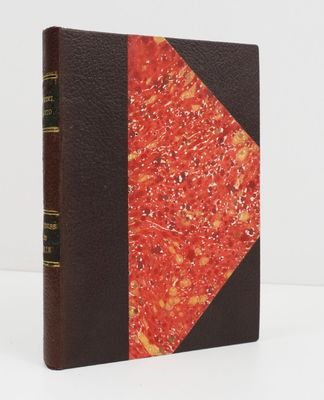 un vieux livre à la couverture rouge et à la reliure noire