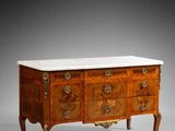an antique chest of drawers with marble top and brass handles