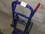 a blue hand truck with a red handle in a room