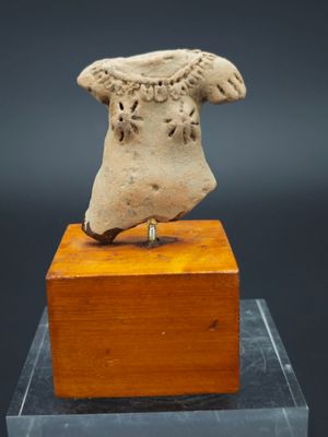 un gros plan sur une statue représentant une tête posée sur un bloc de bois