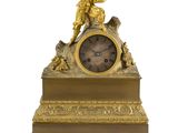une horloge en or surmontée d'une statue