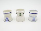 three white cups with blue designs on them sitting next to each other