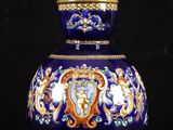un vase bleu orné d'une bordure dorée, surmonté d'une lampe