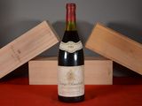 a bottle of wine sitting on a table next to a wooden box