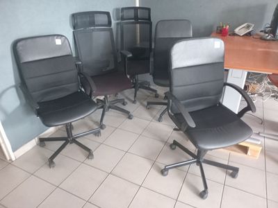 four office chairs in a room with a desk and a chair