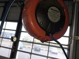 une photo d'une voiture dans un garage, avec un tuyau raccordé au plafond