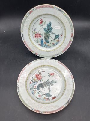 two plates with birds and flowers on them sitting on a table