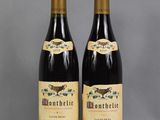 two bottles of wine sitting next to each other on a table