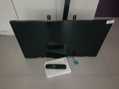 a flat screen tv sitting on the floor next to a remote control