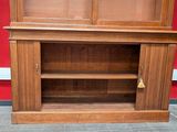 a wooden cabinet with a glass door on the top