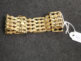 a gold bracelet that has a tag on it